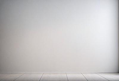 The primary subject of the image is a white wall. The setting is a room with a wooden floor. The visual style is a photo, and the colors and mood are predominantly white, giving the image a clean and minimalist appearance.