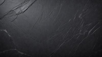 The primary subject of the image is a black marble countertop. The setting is a dark room, and the visual style is a close-up of the marble countertop. The countertop appears to be a dark grey color, giving it a moody and sophisticated appearance.