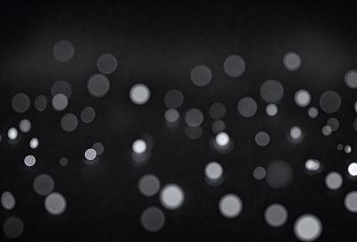 The primary subject of the image is a cluster of bright lights, which are the main objects in the scene. The setting is a dark background, creating a contrast between the lights and the surrounding environment. The visual style of the image is a close-up of the lights, emphasizing their brightness and intensity. The colors and mood of the image are predominantly white and bright, giving the impression of a luminous and vibrant atmosphere.