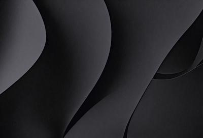 The primary subject of the image is a black and white photo of a spiral pattern. The setting is a black background, which emphasizes the spiral pattern. The visual style is a close-up of the spiral, showcasing its intricate details. The colors and mood of the image are predominantly black and white, giving it a classic and timeless appearance.