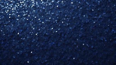 The primary subject of the image is a blue background with a pattern of white circles. The setting appears to be a dark room, and the visual style is a close-up of the blue background with the white circle pattern. The colors and mood of the image are predominantly dark and moody, with the blue background and white circles creating a visually striking contrast.