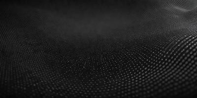 The primary subject of the image is a black surface with a pattern of small white dots. The setting is a dark background, and the visual style appears to be a pattern or texture. The dominant colors are black and white, creating a mood of contrast and simplicity.