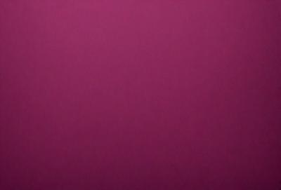 The primary subject of the image is a large, pink wall. The setting is a room with a purple background. The visual style is a close-up of the wall, which gives a sense of depth and texture. The colors and mood of the image are predominantly purple, creating a calm and serene atmosphere.