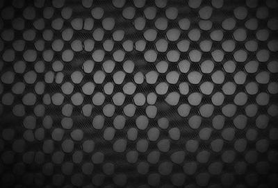 The primary subject of the image is a pattern of black and white circles. The setting is a black background, which creates a striking contrast with the circles. The visual style is a close-up of the circles, showcasing their intricate design. The colors and mood of the image are predominantly black and white, giving it a classic and timeless appearance.