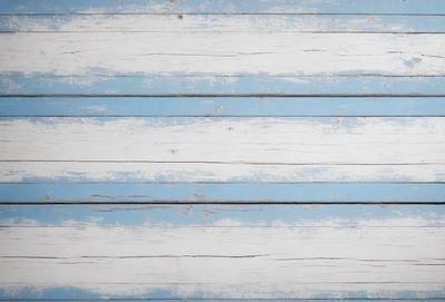 The primary subject of the image is a wooden wall with a blue and white striped pattern. The setting is a room with a blue and white striped wall, which creates a visually appealing and cohesive atmosphere. The visual style of the image is a photo, capturing the details and textures of the wooden wall. The colors and mood of the image are predominantly blue and white, giving it a clean and calming appearance.