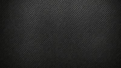 The primary subject of the image is a black background with a patterned texture. The setting is a dark room, and the visual style is a close-up of the patterned surface. The colors and mood of the image are predominantly dark and moody, with the black background and patterned texture creating a dramatic and intense atmosphere.