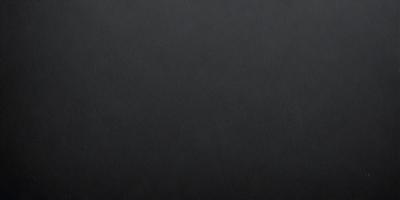 The primary subject of the image is a black background. The setting is a dark room, and the visual style is a black and white photo. The colors and mood of the image are dark and moody, creating a sense of mystery or drama.