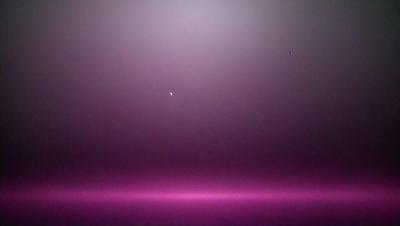 The primary subject of the image is a single star, which is located in the middle of the scene. The setting is a dark, pink background, which creates a contrasting and dramatic atmosphere. The visual style of the image is a photo, capturing the star in its natural environment. The colors and mood of the image are predominantly dark and moody, with the pink background adding a touch of warmth and contrast to the overall scene.