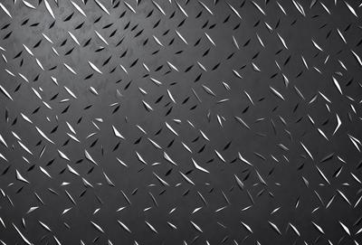 The primary subject of the image is a close-up of a black surface with a pattern of white lines. The setting appears to be a dark room, and the visual style is a combination of a photo and a pattern. The dominant colors are black and white, creating a mood of contrast and depth.