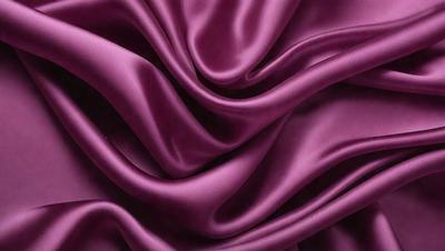 The primary subject of the image is a purple fabric, which is the main object, scene, or focus of the image. The setting or background is a purple fabric, and the visual style is a photo. The dominant colors and overall atmosphere are purple, creating a visually appealing and elegant scene.
