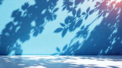 The primary subject of the image is a tree with leaves, which is the main object in the scene. The tree is located in front of a blue wall, creating a contrast between the green leaves and the blue background. The visual style of the image is a photo, capturing the natural beauty of the tree and its surroundings. The colors and mood of the image are predominantly green and blue, with the tree's leaves providing a sense of freshness and tranquility.