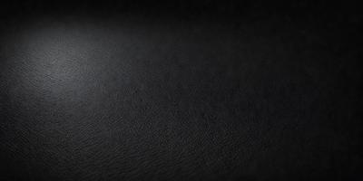 The primary subject of the image is a black leather surface. The setting is a dark room, and the visual style is a close-up of the leather surface. The colors and mood of the image are predominantly dark and moody, with the black leather being the main focus.