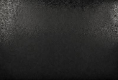 The primary subject of the image is a black leather seat. The setting is a dark room, and the visual style is a close-up of the seat. The colors and mood of the image are predominantly dark, with the black leather seat being the main focus.