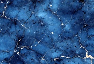 The primary subject of the image is a blue marble wall with a pattern of white dots. The setting is a room with a blue marble wall, and the visual style is a photo. The dominant colors are blue and white, creating a calm and serene atmosphere.