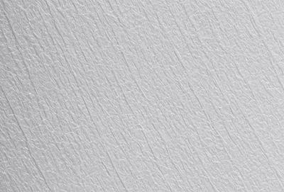 The primary subject of the image is a white wall with a patterned texture. The setting is a room with a white wall, and the visual style is a close-up of the wall. The dominant colors are white and gray, creating a clean and minimalist atmosphere.