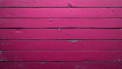 The primary subject of the image is a red wooden wall. The setting is a room with a red wall, and the visual style is a close-up of the wall. The dominant colors are red, and the overall atmosphere is bold and striking.