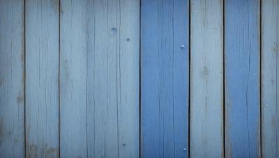 The primary subject of the image is a wooden wall with a blue and white striped pattern. The setting is a room with a blue and white striped wall, and the visual style is a photo. The dominant colors are blue and white, creating a calm and soothing atmosphere.