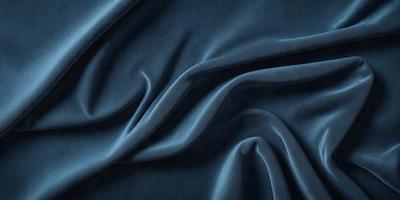 The primary subject of the image is a blue fabric, which appears to be a piece of cloth or a curtain. The setting is a dark room, and the visual style is a close-up of the fabric. The colors and mood of the image are predominantly dark and moody, with the blue fabric being the main focus.