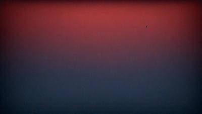 The primary subject of the image is a red sky, which creates a striking contrast against the darker background. The setting appears to be a nighttime scene, with the sky being the main focus of the image. The visual style of the image is a photo, capturing the beauty of the red sky and the darkness of the night. The colors and mood of the image are dominated by the red hue of the sky, which evokes a sense of warmth and intensity.