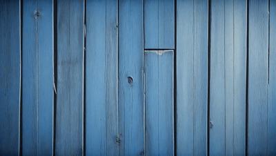 The primary subject of the image is a blue wooden wall. The setting is a room with a blue wooden wall, and the visual style is a photo. The dominant colors are blue and white, creating a calm and serene atmosphere.