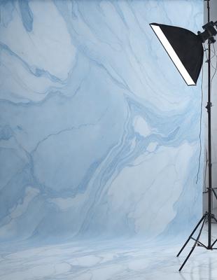 The primary subject of the image is a marble wall with a blue tint. The setting is a studio, and the visual style is a photo. The dominant colors are blue and white, creating a calm and sophisticated atmosphere.