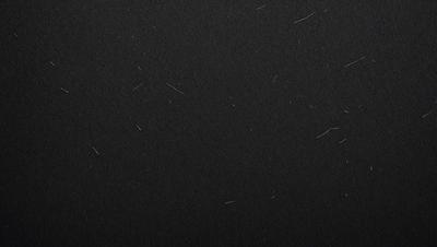 The primary subject of the image is a black background with white lines. The setting is a dark room, and the visual style is a black and white photo. The dominant colors are black and white, creating a moody atmosphere.