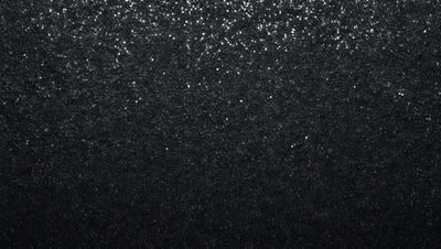 The primary subject of the image is a black background with a pattern of glittering stars. The setting is a dark, starry sky, and the visual style is a combination of a photo and digital art. The colors and mood of the image are predominantly dark and mysterious, with the glittering stars adding a touch of brightness and intrigue.