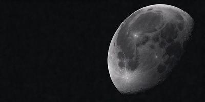 The primary subject of the image is a moon, which is the main object, scene, or focus of the image. The moon is set against a dark background, creating a dramatic contrast. The visual style of the image is a black and white photo, which adds to the overall atmosphere and mood of the scene.