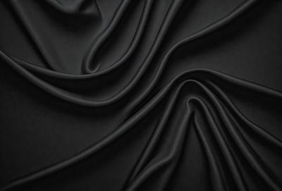 The primary subject of the image is a black fabric, which appears to be a piece of clothing or a curtain. The setting is a dark room, and the visual style is a close-up of the fabric. The colors and mood of the image are predominantly dark and moody, with the black fabric being the main focus.