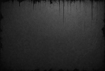 The primary subject of the image is a black background with a few white streaks. The setting is a dark room, and the visual style is a black and white photo. The colors and mood of the image are dark and moody, creating a sense of mystery or drama.
