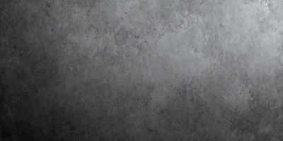 The primary subject of the image is a gray cement wall. The setting is a concrete surface, and the visual style is a photo. The colors and mood of the image are predominantly gray, giving it a somewhat dull and monotonous appearance.
