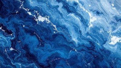 The primary subject of the image is a blue and white ocean wave. The setting is the ocean, with the wave being the main focus of the image. The visual style is a photo of the ocean, capturing the beauty of the waves. The dominant colors are blue and white, creating a serene and calming atmosphere.