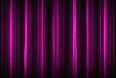 The primary subject of the image is a purple curtain. The setting is a stage or a theater, as the curtain is drawn back, revealing the stage. The visual style is a close-up of the curtain, showcasing its texture and color. The dominant colors are purple and pink, creating a warm and inviting atmosphere.