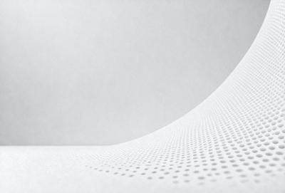 The primary subject of the image is a white wall with a pattern of dots on it. The setting is a room with a white surface, and the visual style appears to be a photo. The dominant colors are white and grey, creating a clean and minimalist atmosphere.