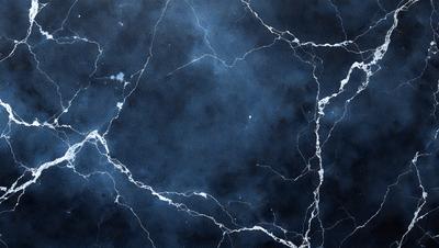 The primary subject of the image is a blue and white marbled wall. The setting is a dark room with a blue and white marbled wall as the main focus. The visual style is a close-up of the marbled wall, showcasing its intricate patterns. The colors and mood of the image are predominantly dark and moody, with the blue and white marbled wall serving as the main source of light and visual interest.