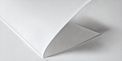 The primary subject of the image is a white paper with a creased or folded shape. The paper appears to be a piece of cardboard or a piece of paper with a creased edge. The setting is a white background, which provides a clean and minimalistic appearance. The visual style is a close-up of the paper, showcasing its texture and creases. The colors and mood of the image are predominantly white, giving it a clean and simple appearance.