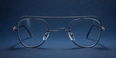 The primary subject of the image is a pair of glasses. The glasses are made of metal and have a silver frame. They are placed on a blue surface, which serves as the setting or background. The visual style of the image is a close-up of the glasses, showcasing their details. The colors in the image are predominantly blue, giving the scene a calm and soothing atmosphere.