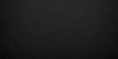 The primary subject of the image is a black background. The setting is a dark room, and the visual style is a black and white photo. The colors and mood of the image are dark and moody, creating a sense of mystery or drama.
