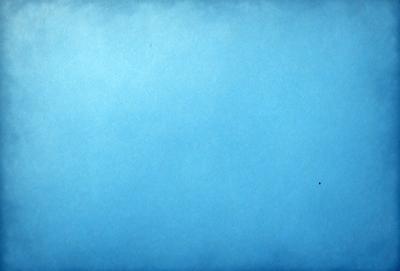 The primary subject of the image is a large, empty blue sky. The setting is a vast, open space with no visible landmarks or objects. The visual style is a simple, clean blue background, which gives the image a calm and serene atmosphere.