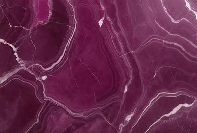 The primary subject of the image is a close-up of a marble surface with a purple hue. The setting is a rocky surface, possibly a marble countertop or a wall. The visual style is a close-up of the marble, showcasing its texture and color. The colors and mood of the image are predominantly purple, giving it a luxurious and elegant appearance.