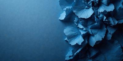 The primary subject of the image is a blue flower, which is the main focus of the scene. The setting is a blue background, which creates a striking contrast with the flower. The visual style of the image is a close-up of the flower, showcasing its details and texture. The dominant colors in the image are blue and green, giving the scene a calm and serene atmosphere.
