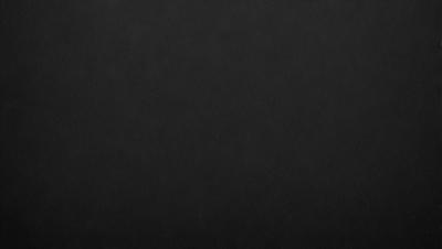 The primary subject of the image is a black background. The setting is a dark room, and the visual style is a black and white photo. The colors and mood of the image are predominantly dark and moody, with a sense of mystery and depth.