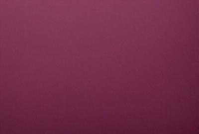 The primary subject of the image is a large, purple wall. The setting is a room with a pink background, giving the scene a warm and inviting atmosphere. The visual style is a close-up of the wall, showcasing its texture and color. The dominant colors are purple and pink, creating a sense of calmness and relaxation.