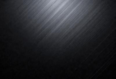 The primary subject of the image is a black background with a silver or gray metal surface. The setting is a dark room, and the visual style is a close-up of the metal surface. The colors and mood of the image are predominantly dark, with the silver or gray metal surface providing a contrasting element.