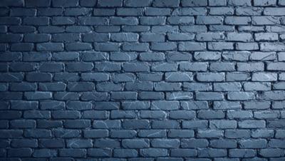The primary subject of the image is a brick wall. The setting is a dark room, and the visual style is a photo. The dominant colors are blue and gray, creating a moody atmosphere.
