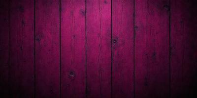 The primary subject of the image is a wooden wall with a purple color. The setting is a room with a wooden surface, and the visual style is a close-up of the wooden wall. The dominant colors are purple and brown, creating a warm and cozy atmosphere.
