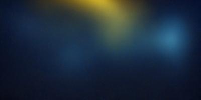 The primary subject of the image is a bright light source, which appears to be a light bulb or a spotlight. The light source is located in the upper-middle part of the image. The setting is a dark room, with the light source being the only bright spot in the scene. The visual style of the image is a close-up of the light source, emphasizing its brightness and intensity. The colors in the image are predominantly dark, with the light source being the only source of illumination. The overall