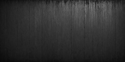 The primary subject of the image is a wooden wall with a black background. The setting is a dark room, and the visual style appears to be a photo. The dominant colors are black and brown, creating a moody atmosphere.