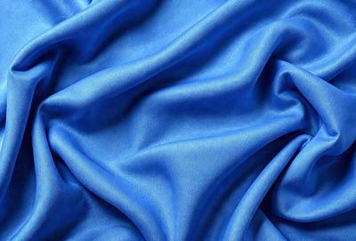 The primary subject of the image is a blue fabric, which is the main object, scene, or focus of the image. The setting or background is a blue cloth, and the visual style is a photo. The dominant colors and overall atmosphere are blue and serene.