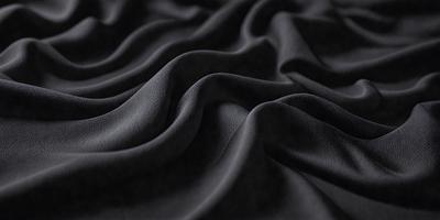 The primary subject of the image is a black fabric with a pattern of waves. The setting is a dark background, and the visual style appears to be a close-up of the fabric. The colors and mood of the image are predominantly dark, with the black fabric being the main focus.